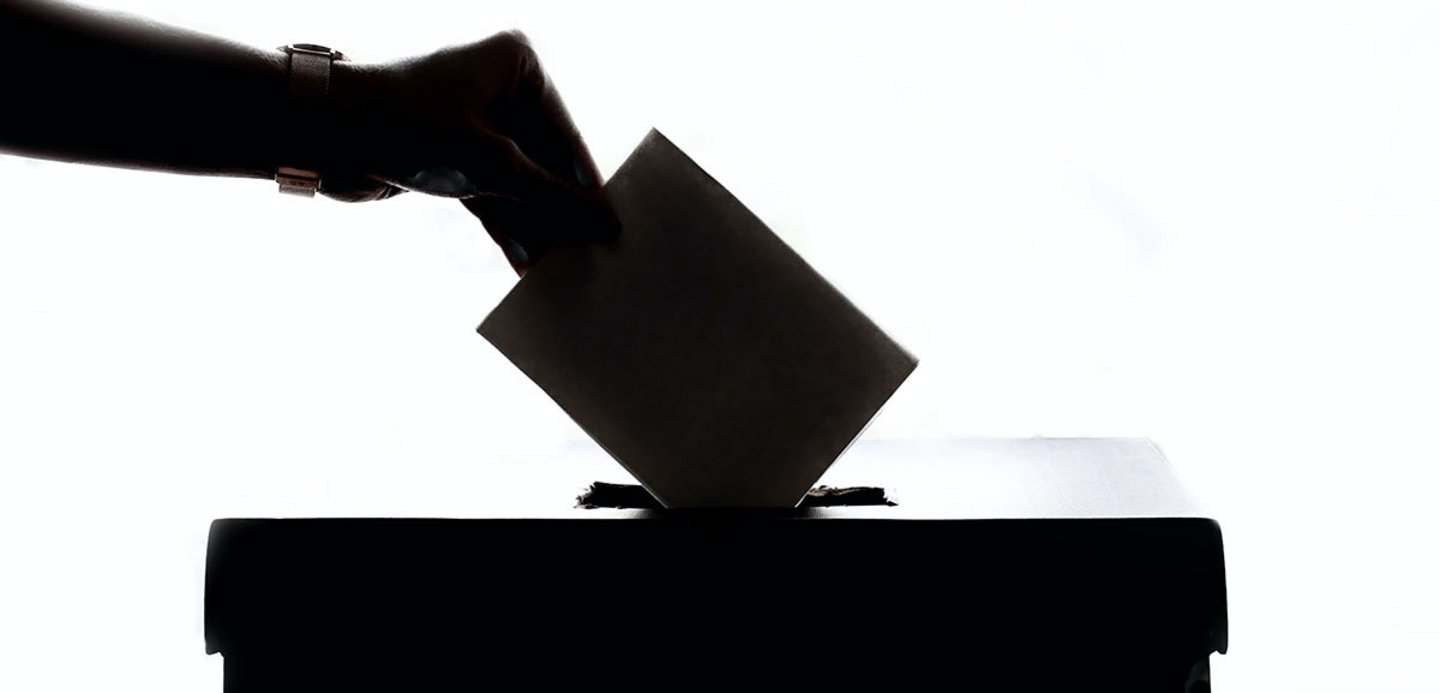 Hand mit Zettel in der Hand - Wahl Symbolbild
