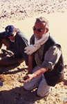 R. Kuper mit Wavy Line Scherbe, die er eben in 70cm Tiefe aus Sondierungsloch geborgen hat. Siedeldüne östlich von Djebel Rahib. / R. Kuper at a dune habitat east of Jebel Rahib with Wavy Line sherd just removed from a narrow bore hole at a depth of 70cm