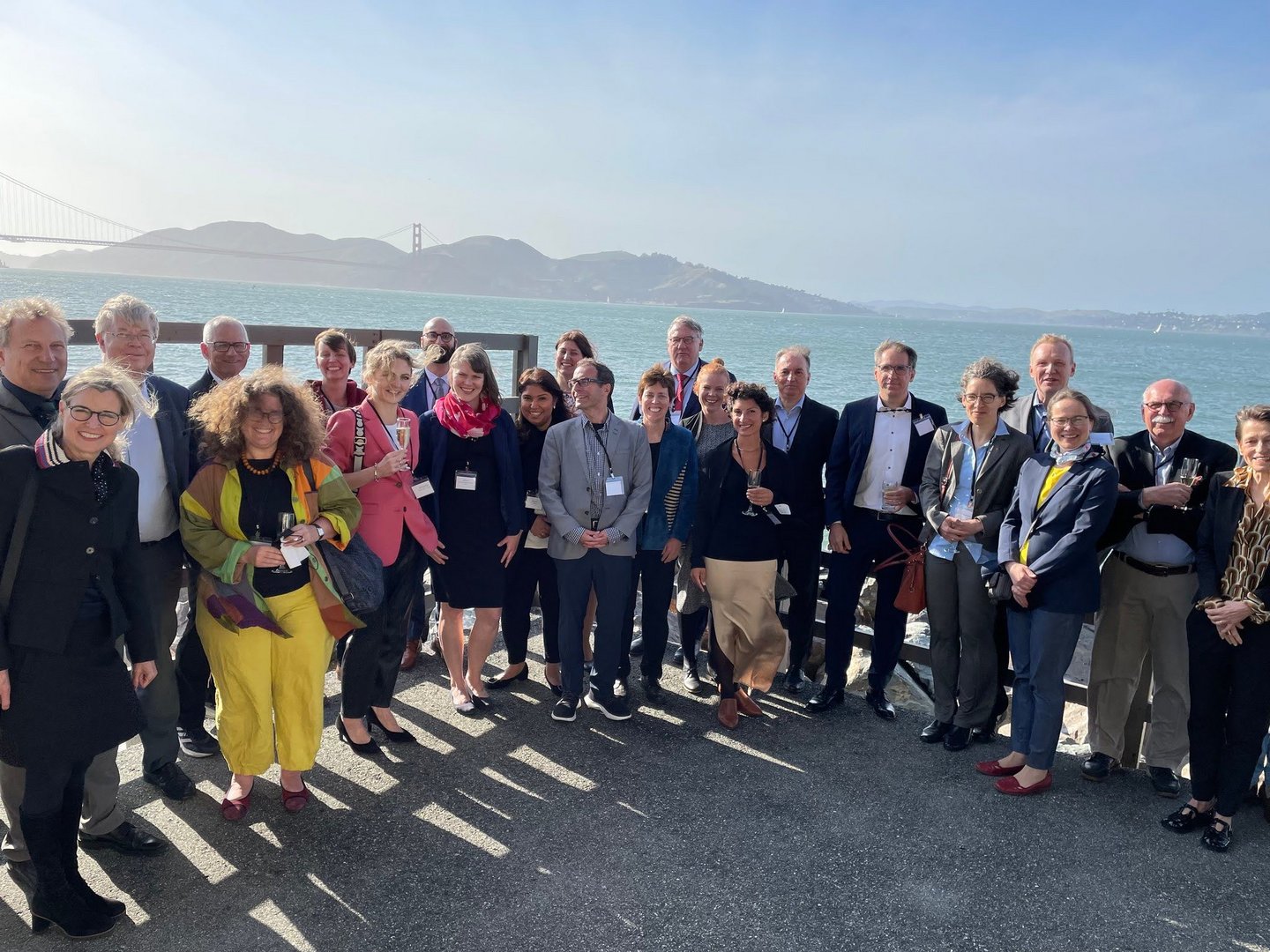 Large group of people standing on a pier in front of the Golden Gate Bridge