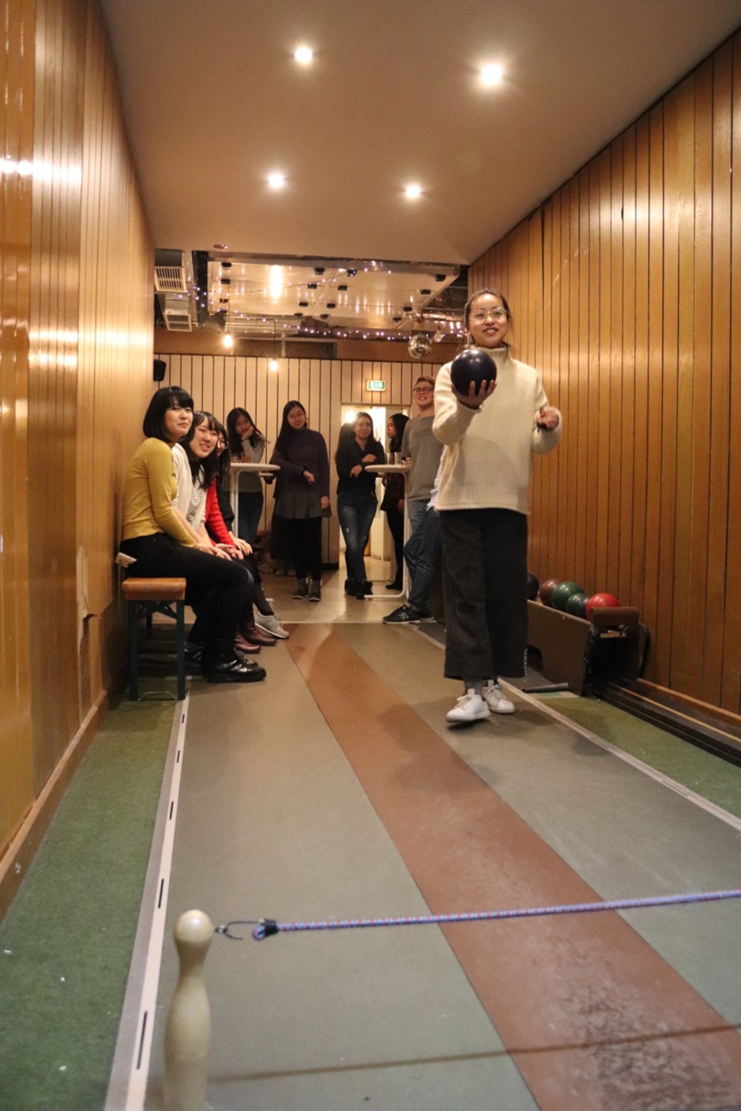 Front view of a student about to bowl. The others a watching her.