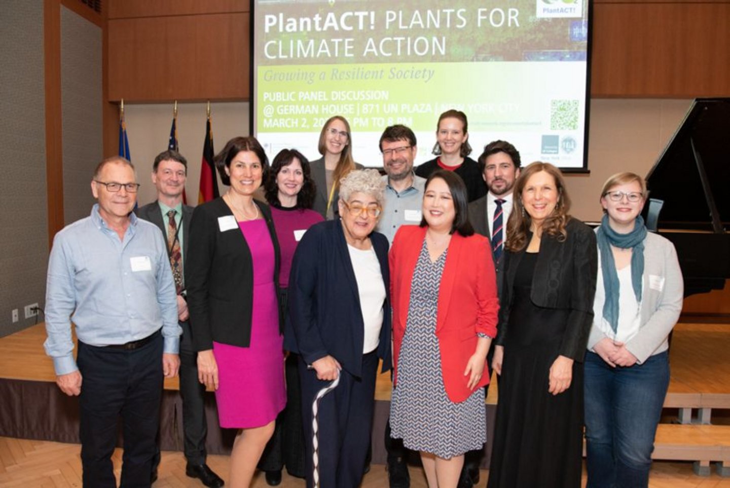 A group of people standing in front of a podium and a banner reading PlantACT! Plants for Climate Action