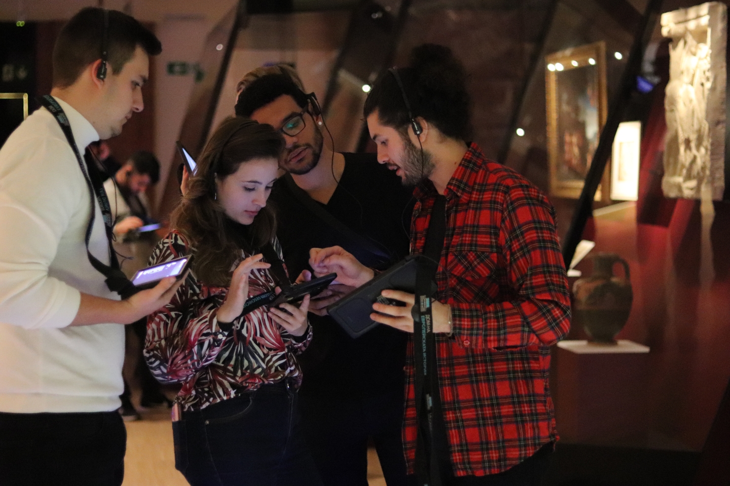 Students with their audio guides talking in the museum