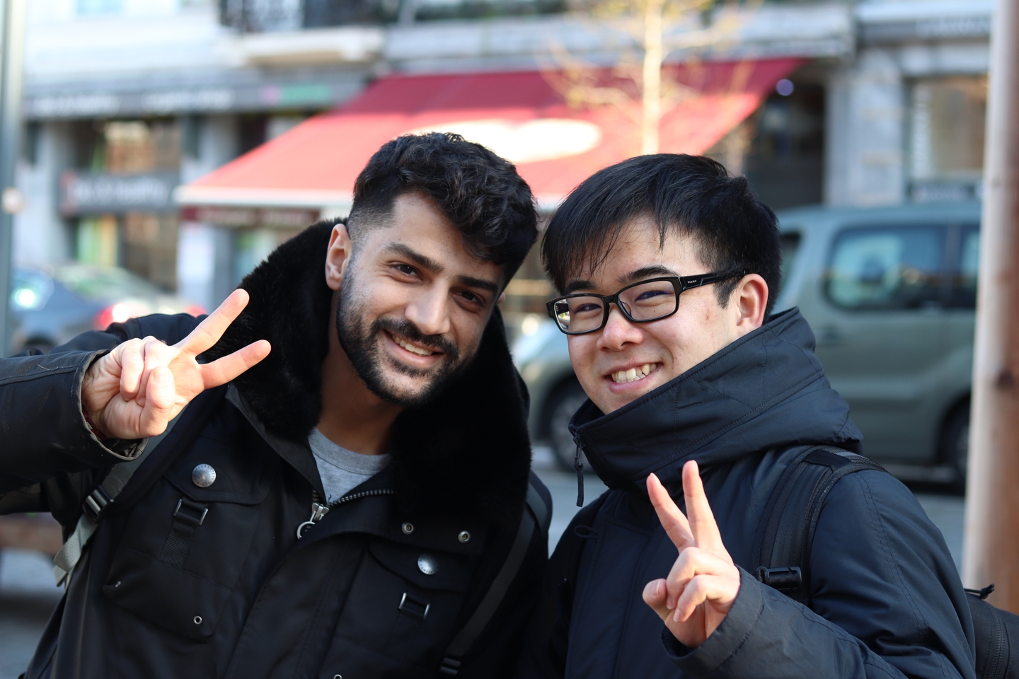 Two students smiling and showing the peace sign at the trip to brussels